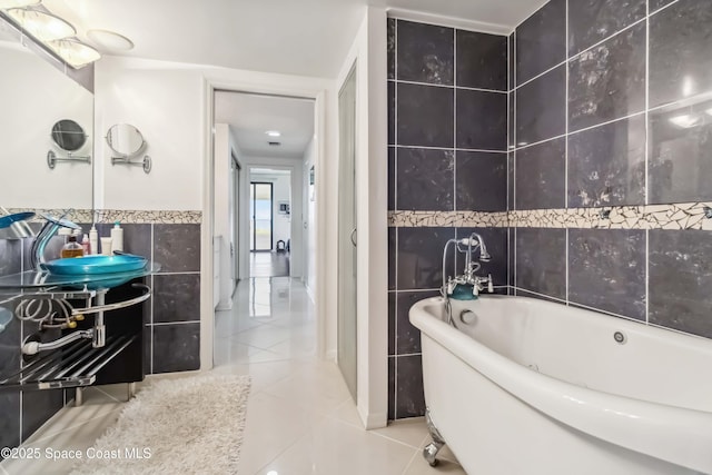 750 N Atlantic Ave Unit 203, Cocoa Beach, FL 32931 - full bath with tile walls, a freestanding bath, tile patterned floors, and vanity