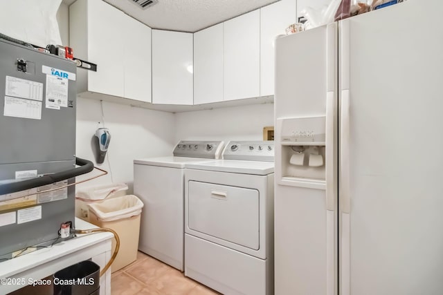 750 N Atlantic Ave Unit 203, Cocoa Beach, FL 32931 - washroom with separate washer and dryer, cabinet space, and heating unit