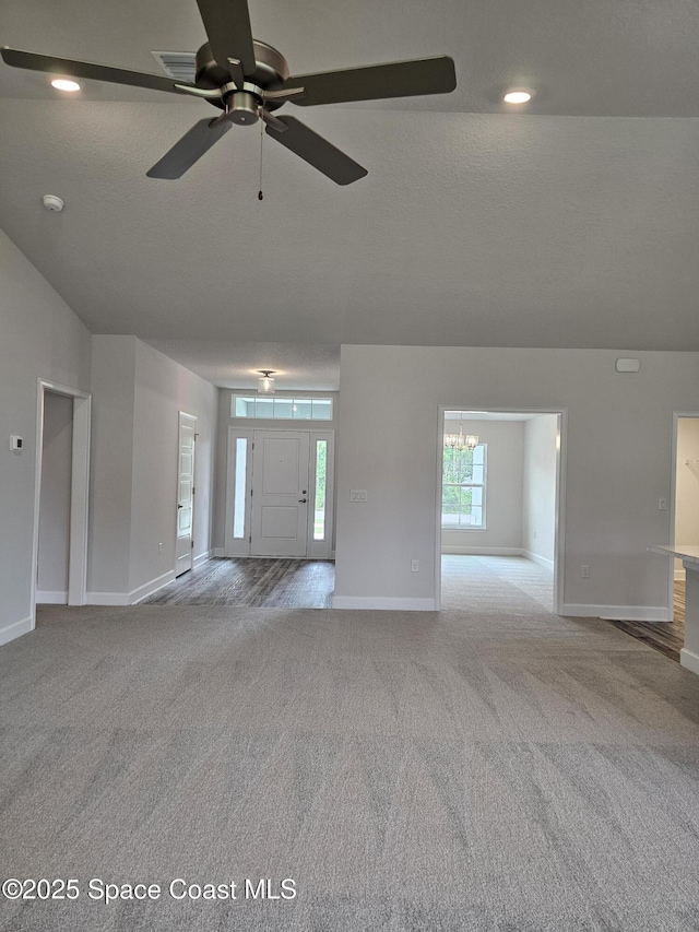 1101 Hanson Ave SW, Palm Bay, FL 32908 - unfurnished living room featuring carpet, lofted ceiling, a ceiling fan, a chandelier, and recessed lighting