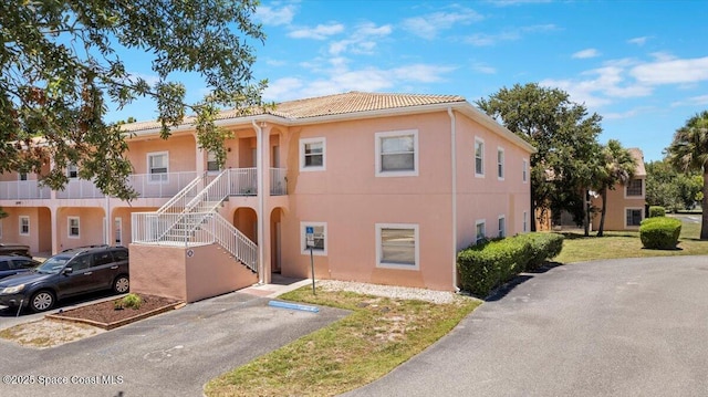 2097 Hidden Grove Ln Unit 106, Merritt Island, FL 32953 - townhome / multi-family property with stucco siding, a tiled roof, and stairway