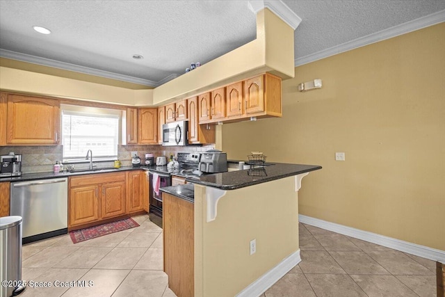 2097 Hidden Grove Ln Unit 106, Merritt Island, FL 32953 - kitchen featuring appliances with stainless steel finishes, a breakfast bar, a peninsula, light tile patterned flooring, and ornamental molding
