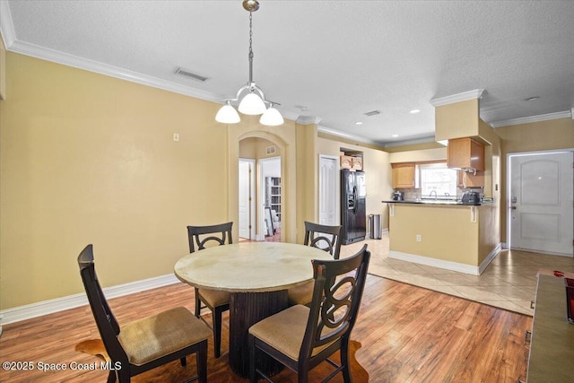 2097 Hidden Grove Ln Unit 106, Merritt Island, FL 32953 - dining space featuring arched walkways, crown molding, light tile patterned flooring, and a textured ceiling
