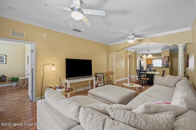2097 Hidden Grove Ln Unit 106, Merritt Island, FL 32953 - living area featuring arched walkways, a ceiling fan, ornate columns, wood finished floors, and ornamental molding