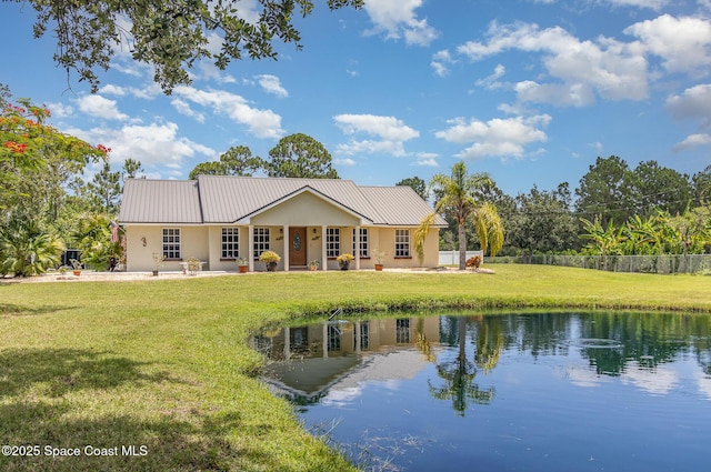 690 Grant Rd, Palm Bay, FL 32909 - rear view of house featuring a yard, stucco siding, a water view, and a metal roof