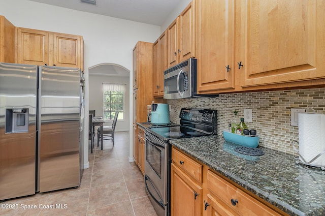 690 Grant Rd, Palm Bay, FL 32909 - kitchen with appliances with stainless steel finishes, light tile patterned flooring, backsplash, and arched walkways