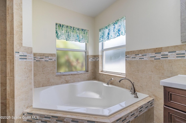 690 Grant Rd, Palm Bay, FL 32909 - full bathroom featuring a bath, tile walls, vanity, and a wainscoted wall