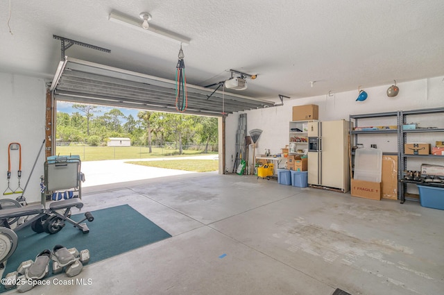 690 Grant Rd, Palm Bay, FL 32909 - garage featuring a garage door opener and white fridge with ice dispenser