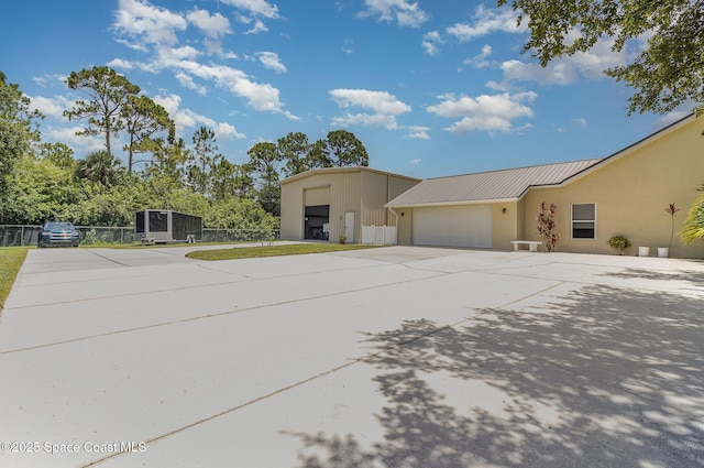 690 Grant Rd, Palm Bay, FL 32909 - view of property exterior with an attached garage, a metal roof, driveway, and stucco siding