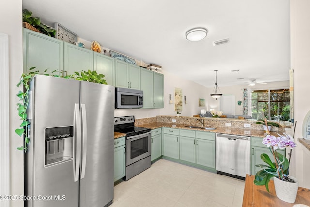 3498 Cutty Sark Way, Indialantic, FL 32903 - kitchen with appliances with stainless steel finishes, green cabinets, hanging light fixtures, and light stone counters