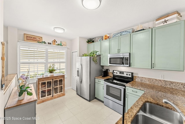 3498 Cutty Sark Way, Indialantic, FL 32903 - kitchen with stainless steel appliances, green cabinets, and light stone countertops