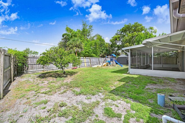 1327 Canterbury Ln, Rockledge, FL 32955 - fenced backyard featuring a sunroom and a playground
