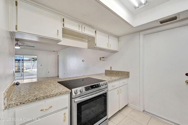 1327 Canterbury Ln, Rockledge, FL 32955 - kitchen featuring stainless steel range with electric stovetop, light countertops, light tile patterned flooring, and white cabinets