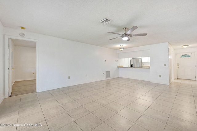 1327 Canterbury Ln, Rockledge, FL 32955 - unfurnished living room with ceiling fan, a textured ceiling, and light tile patterned flooring