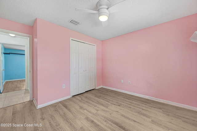 1327 Canterbury Ln, Rockledge, FL 32955 - unfurnished bedroom featuring wood finished floors, a closet, a ceiling fan, and a textured ceiling