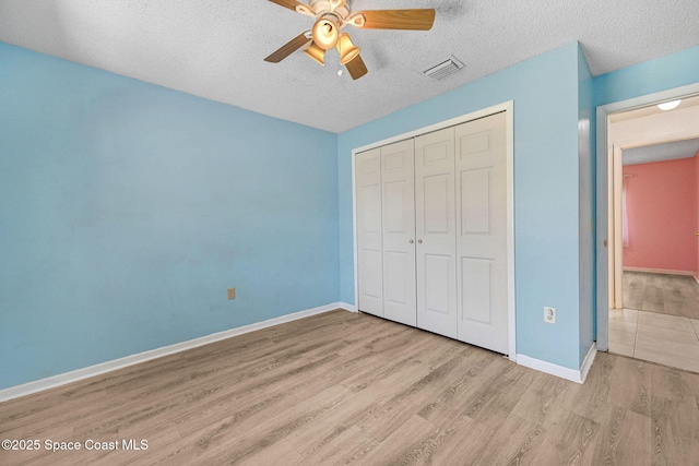 1327 Canterbury Ln, Rockledge, FL 32955 - unfurnished bedroom with wood finished floors, a closet, a textured ceiling, and ceiling fan