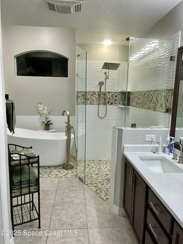 3601 Oneida St, Cocoa, FL 32926 - full bathroom featuring tiled shower, vanity, a soaking tub, a textured ceiling, and tile patterned floors