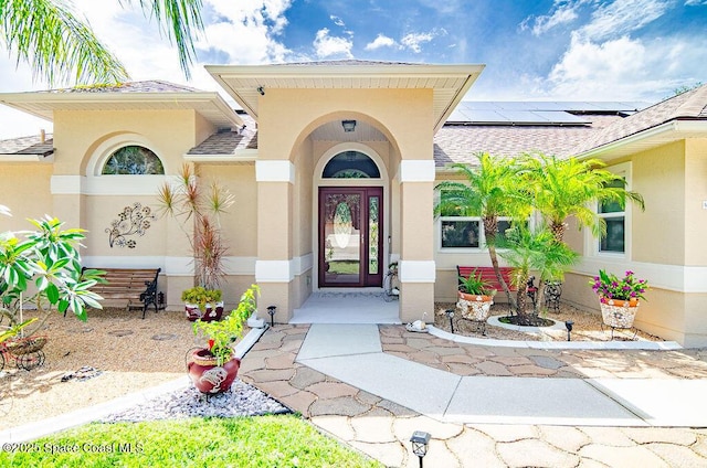 4204 Long Leaf Dr, Melbourne, FL 32940 - doorway to property featuring stucco siding, solar panels, and a shingled roof