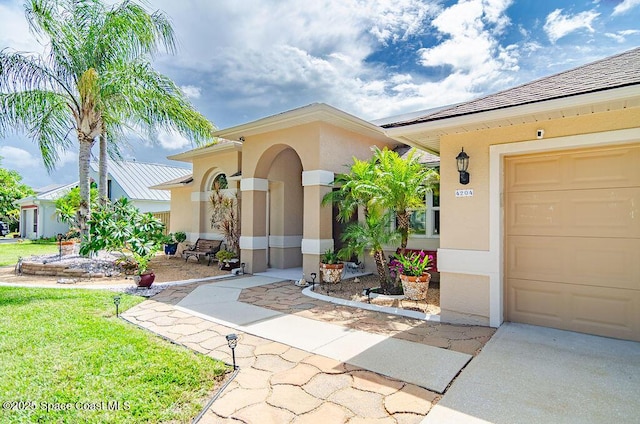 4204 Long Leaf Dr, Melbourne, FL 32940 - view of exterior entry with stucco siding, concrete driveway, and a lawn