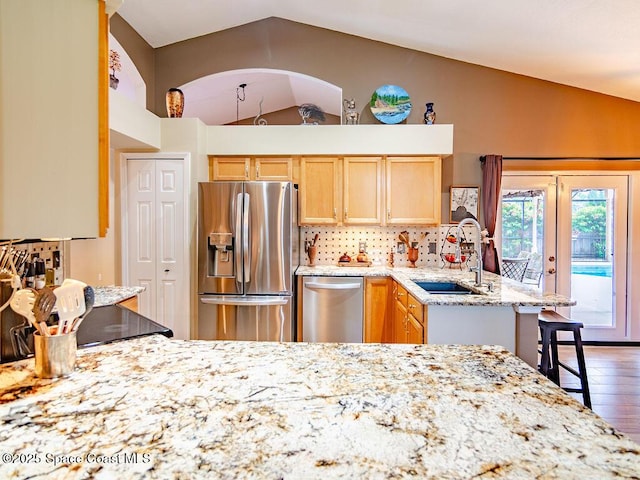 4204 Long Leaf Dr, Melbourne, FL 32940 - kitchen with stainless steel appliances, lofted ceiling, light brown cabinetry, tasteful backsplash, and light stone countertops