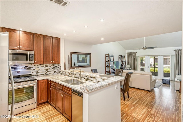 443 Hawthorne Ct, Indian Harbour Beach, FL 32937 - kitchen with stainless steel appliances, a peninsula, light wood-style floors, tasteful backsplash, and recessed lighting