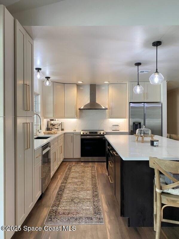2940 Friday Ln, Cocoa, FL 32926 - kitchen featuring appliances with stainless steel finishes, wall chimney exhaust hood, light countertops, hanging light fixtures, and dark wood-type flooring