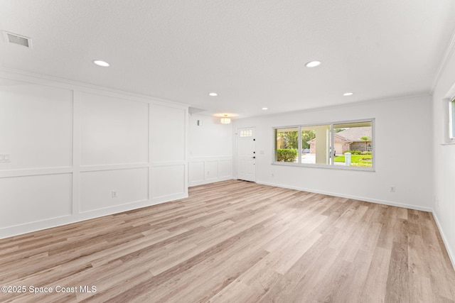 332 Nikomas Way, Melbourne Beach, FL 32951 - spare room with a decorative wall, light wood-style flooring, recessed lighting, and crown molding