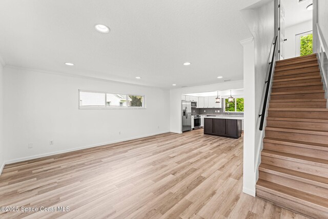332 Nikomas Way, Melbourne Beach, FL 32951 - unfurnished living room featuring stairway, recessed lighting, plenty of natural light, and light wood-style floors