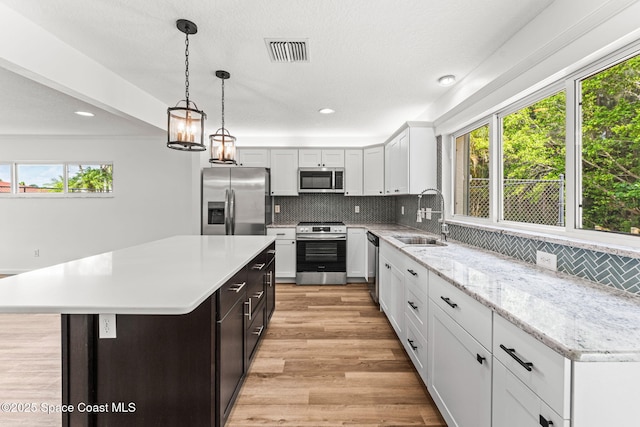 332 Nikomas Way, Melbourne Beach, FL 32951 - kitchen featuring stainless steel appliances, plenty of natural light, decorative backsplash, recessed lighting, and light wood-style floors