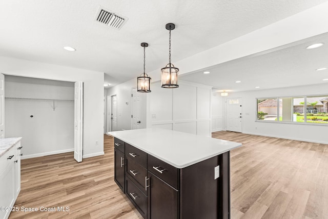 332 Nikomas Way, Melbourne Beach, FL 32951 - kitchen with light wood-style floors, light countertops, decorative light fixtures, recessed lighting, and dark brown cabinets