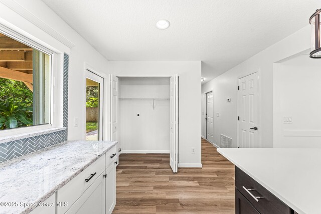 332 Nikomas Way, Melbourne Beach, FL 32951 - kitchen featuring light wood-style floors, decorative backsplash, recessed lighting, white cabinets, and a textured ceiling
