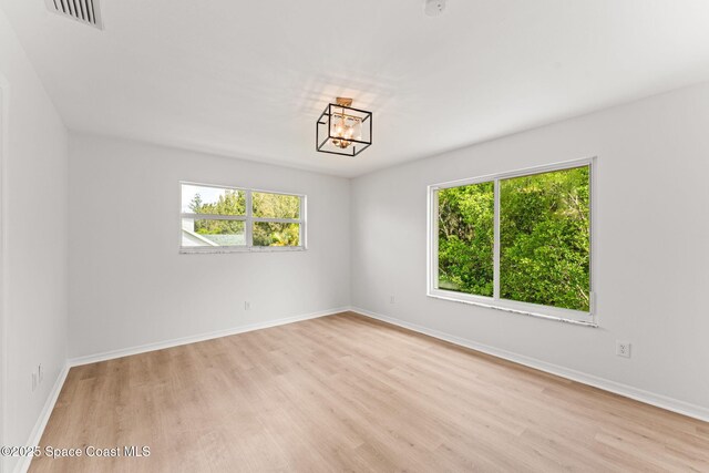 332 Nikomas Way, Melbourne Beach, FL 32951 - unfurnished room with wood finished floors and a chandelier
