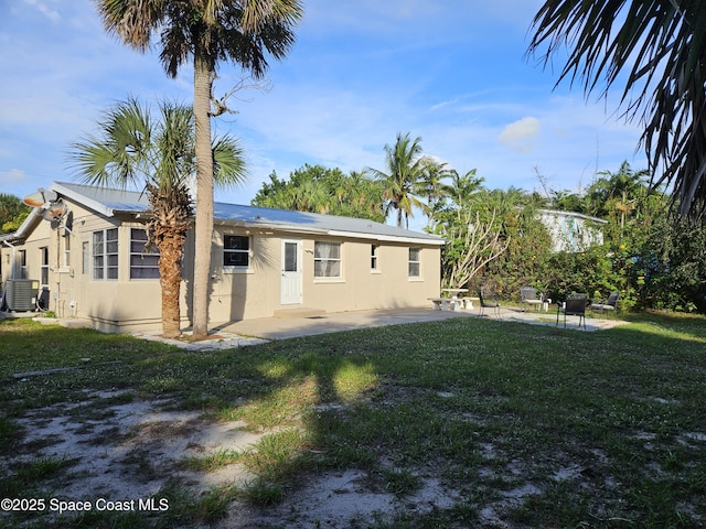 109 Fontaine St, Melbourne Beach, FL 32951 - rear view of house with a patio area, a lawn, and stucco siding