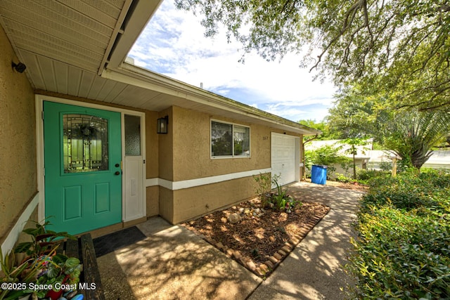 767 Adolph Ln, Cocoa, FL 32927 - view of exterior entry with stucco siding, concrete driveway, and a garage