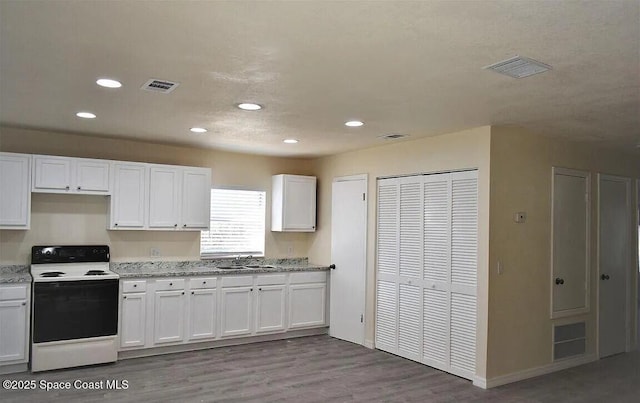 3717 Pinewood Dr NE Unit 12, Palm Bay, FL 32905 - kitchen with electric stove, white cabinetry, recessed lighting, light wood-type flooring, and light stone countertops
