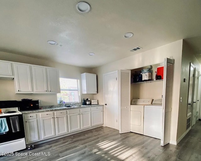3717 Pinewood Dr NE Unit 12, Palm Bay, FL 32905 - kitchen featuring range with electric cooktop, washer and dryer, white cabinets, dark wood-type flooring, and recessed lighting