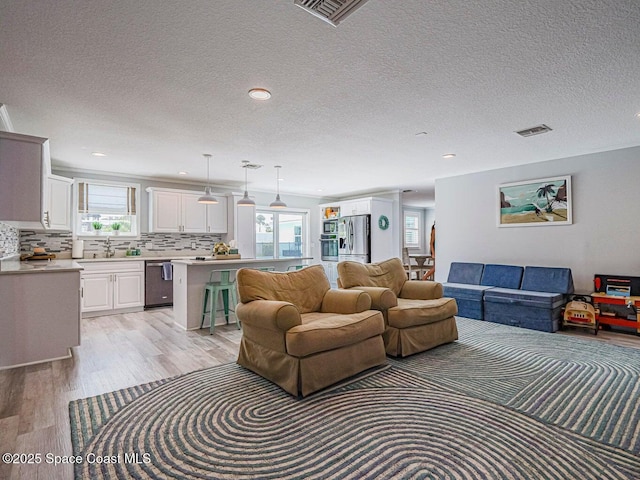 406 9th Ct, Vero Beach, FL 32962 - living room with light wood finished floors, a textured ceiling, and recessed lighting