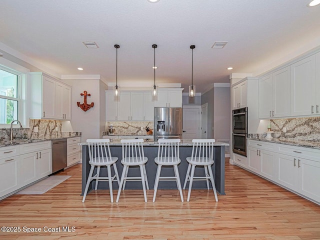 406 9th Ct, Vero Beach, FL 32962 - kitchen with appliances with stainless steel finishes, backsplash, white cabinets, and recessed lighting