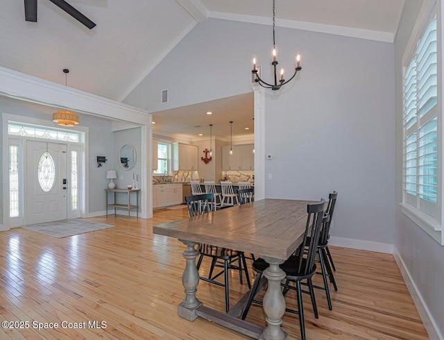 406 9th Ct, Vero Beach, FL 32962 - dining area with a chandelier, light wood-type flooring, plenty of natural light, high vaulted ceiling, and beamed ceiling