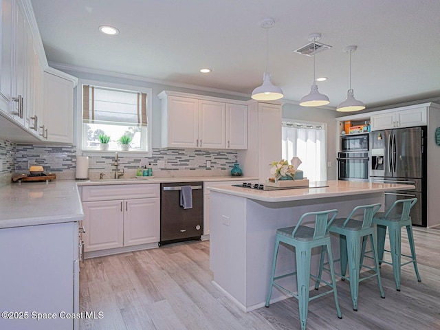 406 9th Ct, Vero Beach, FL 32962 - kitchen with appliances with stainless steel finishes, white cabinets, light wood finished floors, light countertops, and recessed lighting
