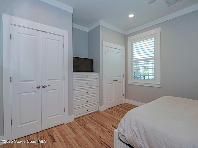 406 9th Ct, Vero Beach, FL 32962 - bedroom featuring multiple closets, light wood-style flooring, recessed lighting, and crown molding