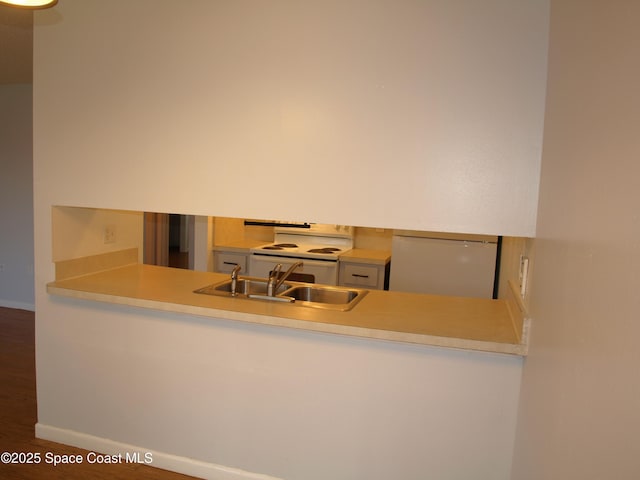 292 San Juan Cir, Melbourne, FL 32935 - kitchen with refrigerator, electric stove, wood finished floors, and a peninsula
