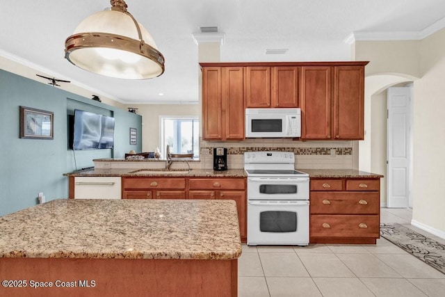 770 S Easy St, Sebastian, FL 32958 - kitchen featuring white appliances, crown molding, brown cabinetry, light stone counters, and light tile patterned floors