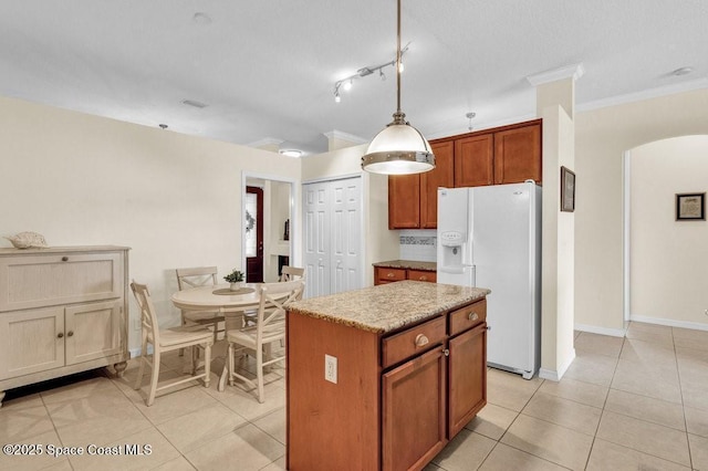 770 S Easy St, Sebastian, FL 32958 - kitchen with white fridge with ice dispenser, arched walkways, a kitchen island, light tile patterned flooring, and hanging light fixtures
