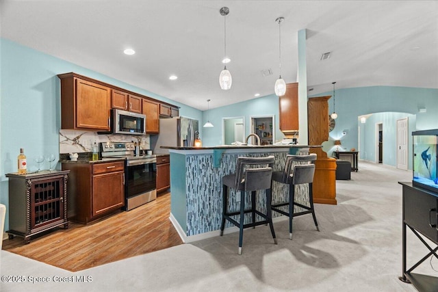1787 Attilburgh Blvd, West Melbourne, FL 32904 - kitchen with stainless steel appliances, dark countertops, a breakfast bar, decorative light fixtures, and arched walkways