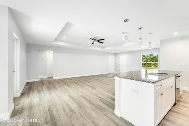 2181 Wagonwheel Ave SE, Palm Bay, FL 32909 - kitchen featuring a raised ceiling, light wood finished floors, light stone countertops, white cabinets, and decorative light fixtures