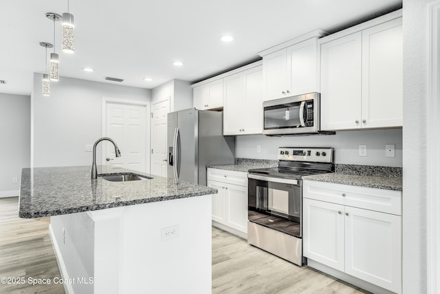 2181 Wagonwheel Ave SE, Palm Bay, FL 32909 - kitchen with appliances with stainless steel finishes, light wood-type flooring, white cabinetry, and recessed lighting