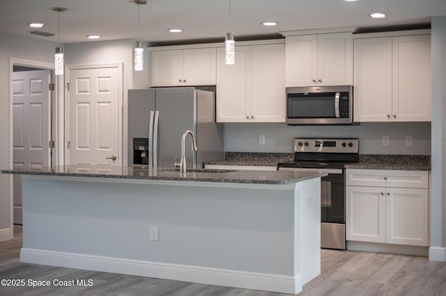 2181 Wagonwheel Ave SE, Palm Bay, FL 32909 - kitchen featuring stainless steel appliances, light wood-style flooring, a center island with sink, recessed lighting, and white cabinets