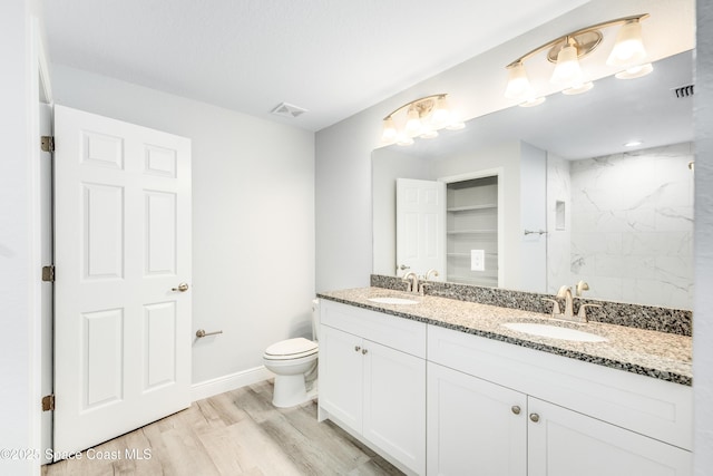 2181 Wagonwheel Ave SE, Palm Bay, FL 32909 - full bathroom with double vanity, a marble finish shower, and wood finished floors