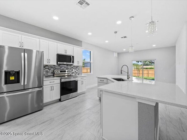 3358 Nancy St, West Melbourne, FL 32904 - kitchen featuring appliances with stainless steel finishes, white cabinetry, plenty of natural light, and recessed lighting