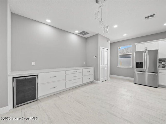 3358 Nancy St, West Melbourne, FL 32904 - kitchen featuring stainless steel fridge, white cabinetry, light countertops, recessed lighting, and decorative light fixtures